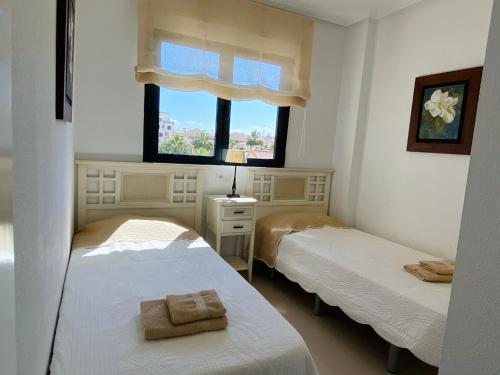 two beds in a room with a window at Regia Bahia en Cabo Roig in Orihuela Costa
