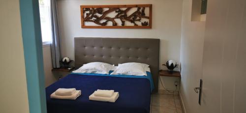 a bedroom with a blue bed with towels on it at Résidence B&L Lagon : T3 Alizés in Sainte-Luce