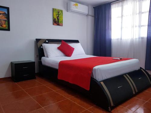 a bedroom with a bed with a red blanket at Hotel Media Luna in Santa Marta