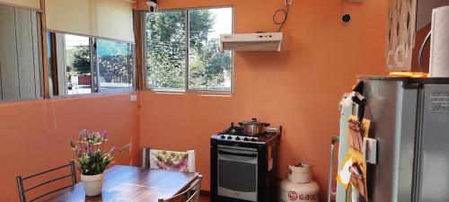 a kitchen with a table and a stove and a refrigerator at Hospedaje La ruta Los Angeles in Los Ángeles