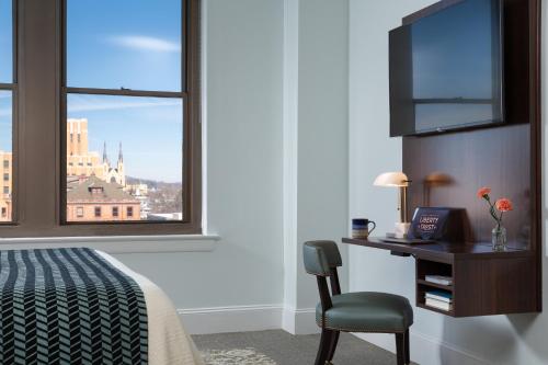 a hotel room with a desk and a window at The Liberty Trust in Roanoke