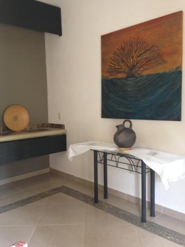a room with a table and a painting on the wall at Hotel Boutique Casa de Campo Malinalco in Malinalco