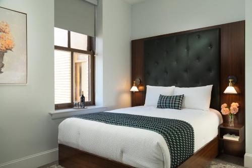 a bedroom with a large bed with a black headboard at The Liberty Trust in Roanoke