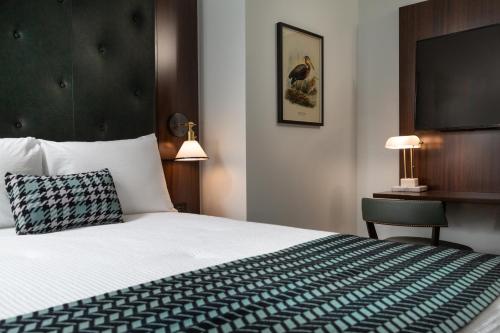a hotel room with a large bed and a desk at The Liberty Trust in Roanoke