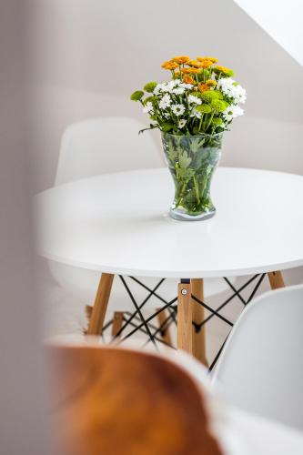a vase of flowers sitting on a table at Sopot Pier Apartments by OneApartments in Sopot