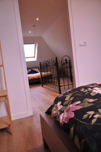 a bedroom with a bed and a staircase with a window at Vakantiehuisje Opdekamp in Merselo