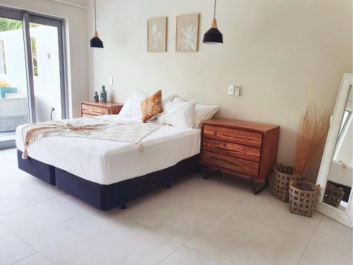 a bedroom with a bed and a dresser and a window at Mama Taras Luxury Villa in Ngatangiia
