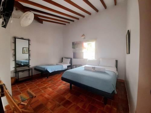 a bedroom with two beds and a mirror on the wall at Hotel Villa Del Socorro in Socorro