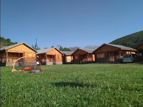 a yard with a playground in the grass with houses at Bungalows Laspaúles in Laspaúles