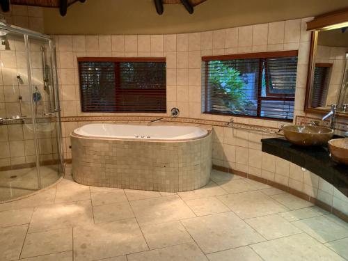 a large bathroom with a tub and two sinks at Marina Views Guesthouse in Hartbeespoort