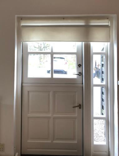 a white garage door with a window at AppleFlower Farm retro apartment in Lillerød