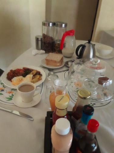 a table with breakfast foods and drinks on it at Lapaleholo Guesthouse in Phuthaditjhaba