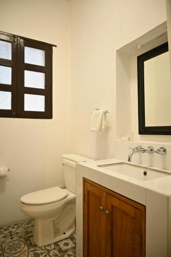 ein Badezimmer mit Toilette, Waschbecken und Spiegel in der Unterkunft Hotel Rancho El Morillo in Saltillo