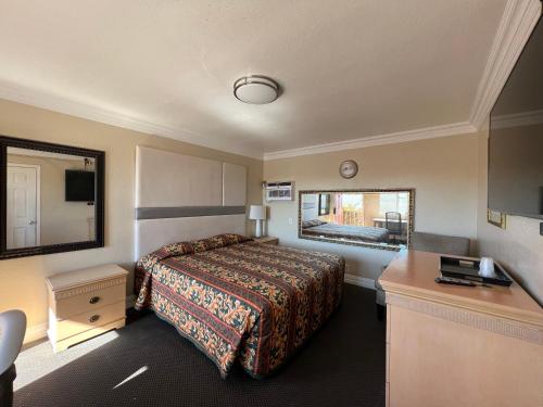 a hotel room with a bed and a desk at Flamingo Motel Oxnard in Oxnard