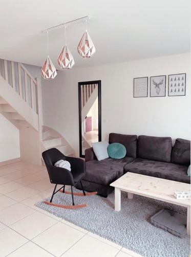 a living room with a couch and a table at Maison La demoiselle de Chambord in Huisseau-sur-Cosson