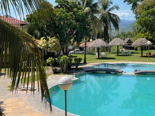 a large blue swimming pool with a palm tree at El Pantanal Hotel & Resort in San José de Chiquitos