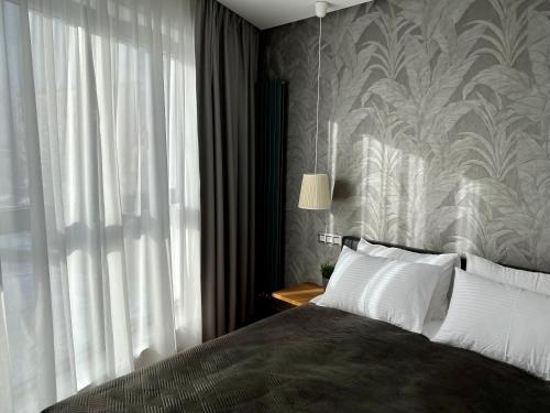 a bedroom with a bed with a large window at Horyzont Luksusowe apartamenty nad morzem z parkingiem Międzyzdroje in Międzyzdroje
