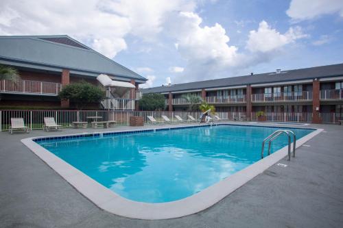 a large swimming pool in front of a hotel at Super 8 by Wyndham Mobile I-65 in Mobile