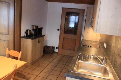 a kitchen with a sink and a table and a door at Beim Hanslbauer in Reit im Winkl