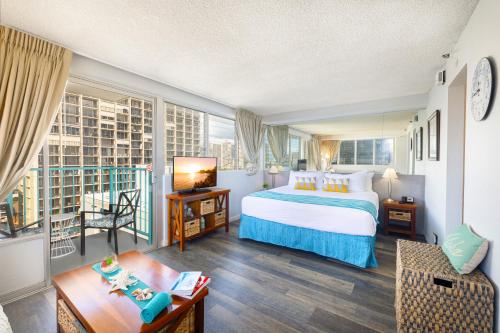 a hotel room with a bed and a balcony at Beautiful Studio in the Heart of Vibrant Waikiki in Honolulu