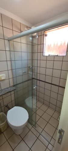 a bathroom with a toilet and a glass shower at diRoma Fiori - Apartamentos JN in Caldas Novas