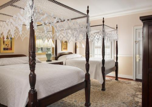 a bedroom with two beds with white comforters at Meeting Street Inn in Charleston