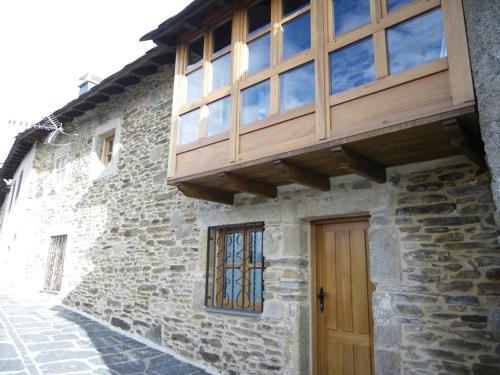 - Edificio con puerta de madera y balcón en Casa Rural Los Cabritos de Tomás, en Puebla de Sanabria