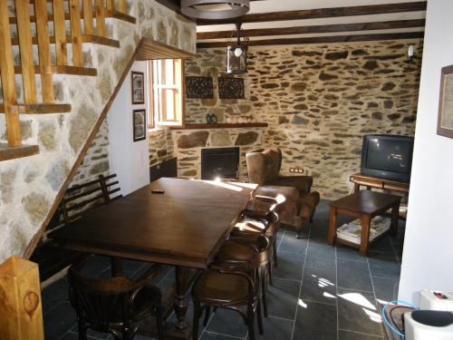 Casa Rural Los Cabritos de Tomás في بويبلا ذي سانابريا: غرفة طعام مع طاولة وكراسي خشبية