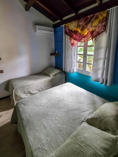 three beds in a room with a window at O Costão do Sol in Balneário Camboriú
