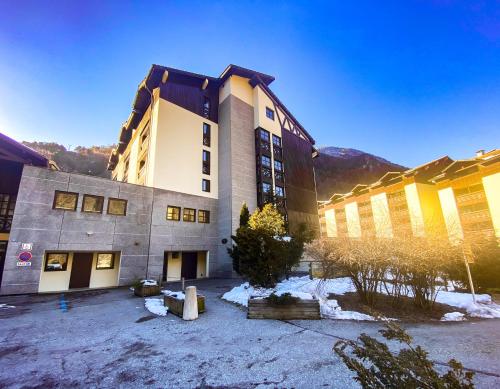 um grande edifício com neve em frente em 1- Studio Brides-les-bains tout confort em Brides-les-Bains