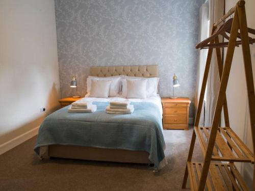 - une chambre avec un lit et 2 serviettes dans l'établissement Stunning Edinburgh 1820s stables converted studio, à Édimbourg