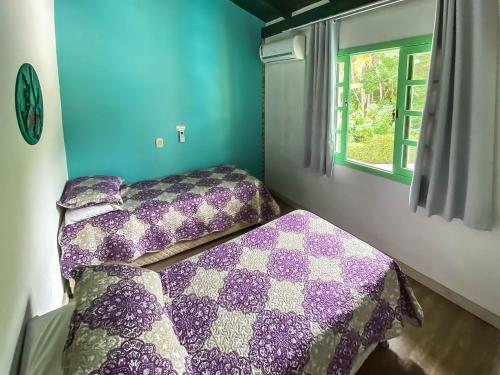 a bedroom with two beds and a window at O Costão do Sol in Balneário Camboriú