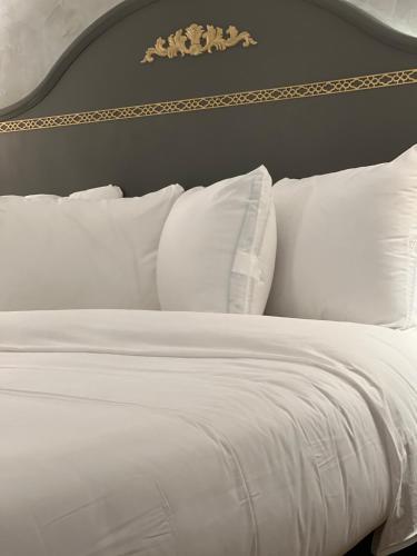 a white bed with white pillows in a bedroom at Chateau Suites in Norristown