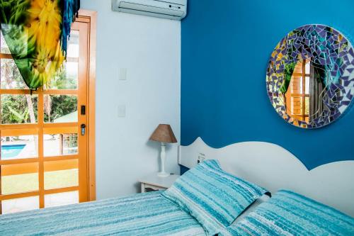 a bedroom with a bed and a mirror on the wall at O Costão do Sol in Balneário Camboriú