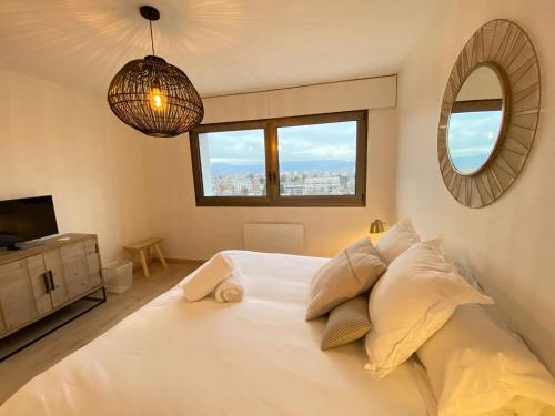 アヌシーにあるLE PANORAMIQUEの白いベッドと鏡のある寝室