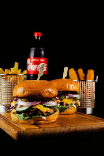 two sandwiches on a cutting board with a bottle of soda at Frank Apartments in Amoudara Herakliou