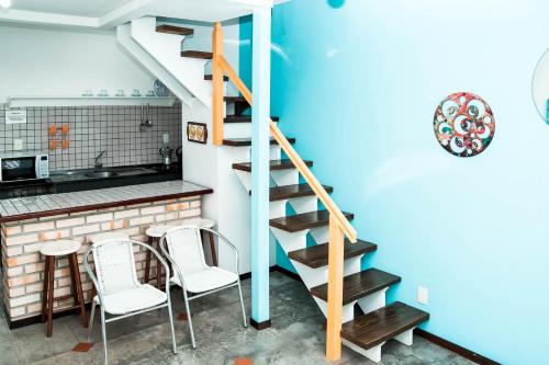 a staircase in a kitchen with two chairs and a table at O Costão do Sol in Balneário Camboriú