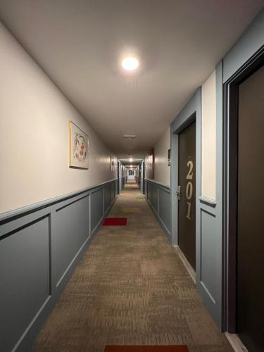 a hallway with a long corridor with a door at Chateau Suites in Norristown