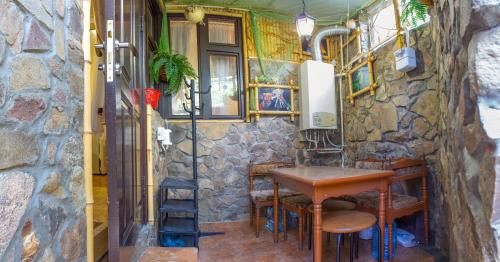 una pequeña mesa y sillas en una habitación con una pared de piedra en U Igorya Holiday Park, en Alushta