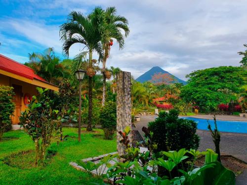 um resort com piscina e uma montanha ao fundo em Hotel Arenal Country Inn em La Fortuna