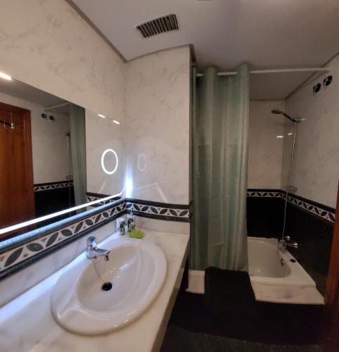 a bathroom with a sink and a shower and a tub at Residencial Esquinzo 2 in Playa Jandia