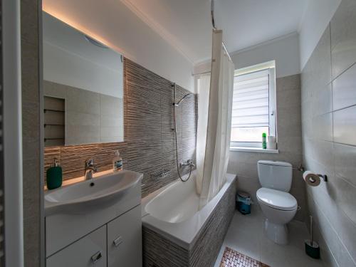 a white bathroom with a sink and a toilet at ERZHAUS Apartments in Eisenerz