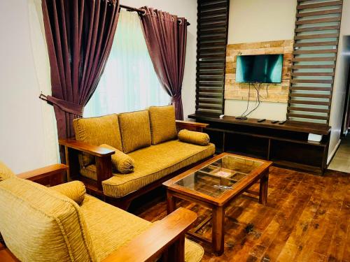 a living room with a couch and a coffee table at Abbi Holidays - Jaffna Luxurious Villa in Jaffna