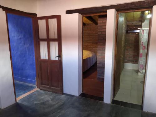 um quarto com uma porta e uma cama num quarto em Piedra Campana alojamiento em Tilcara