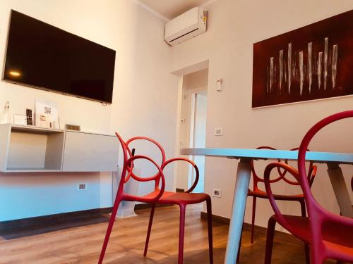 una sala da pranzo con tavolo, 2 sedie e TV di The Square of Miracles Apartment a Pisa