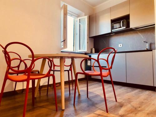 a kitchen with a wooden table and four chairs at The Square of Miracles Apartment in Pisa