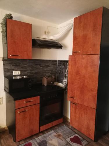 a kitchen with a black stove and wooden cabinets at Gästehaus Ochsenhof in Feuchtwangen