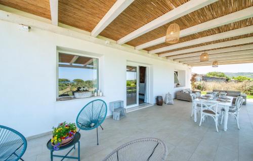 a patio with chairs and a table with a dining room at Bellimpiazza - Villa vista mare con piscina in Sorso