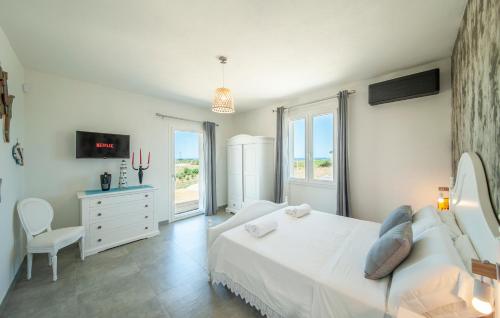 a white bedroom with a bed and a window at Bellimpiazza - Villa vista mare con piscina in Sorso