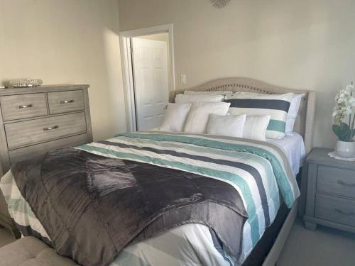 a bedroom with a bed with a dresser and a mirror at Natty’s Cozy Beach house in Hanover Jamaica in Point